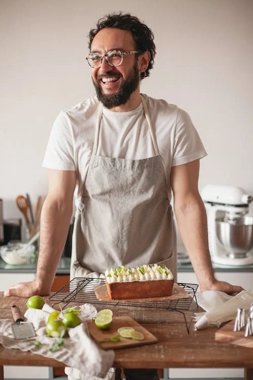 homem de avental sorrindo na cozinha